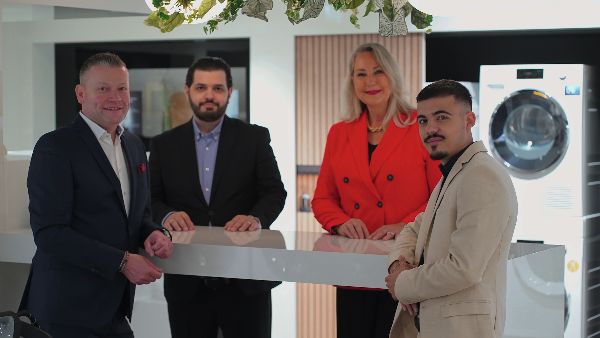 a lady looking at her phone leaning on a kitchen counter