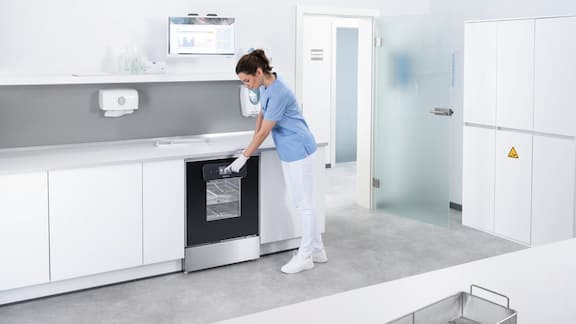A medical assistant selects programme on ExpertLine washer disinfector