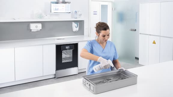 Assistente del medico davanti alla macchina speciale per il lavaggio e la disinfezione da banco