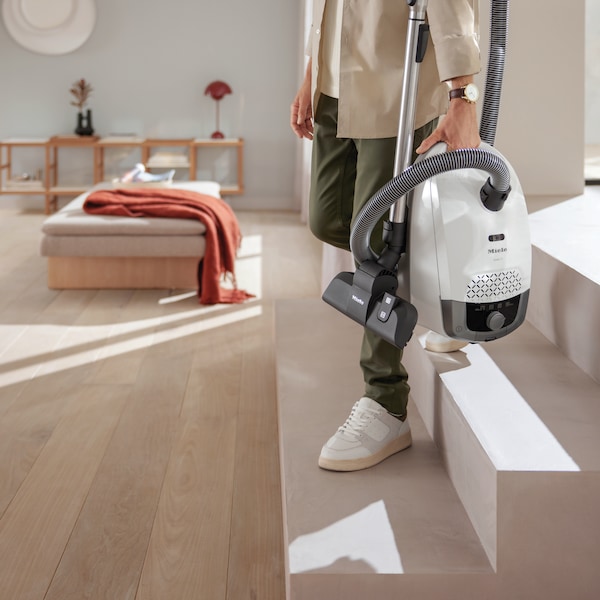 Image of a Miele vacuum cleaner cleaning pet's hair on the couch