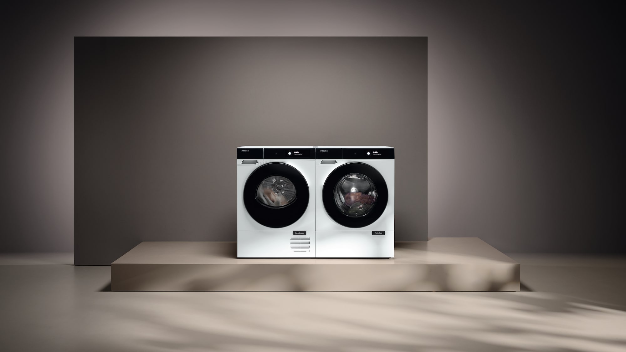 laundry room with hanged shirts and Miele washing machine