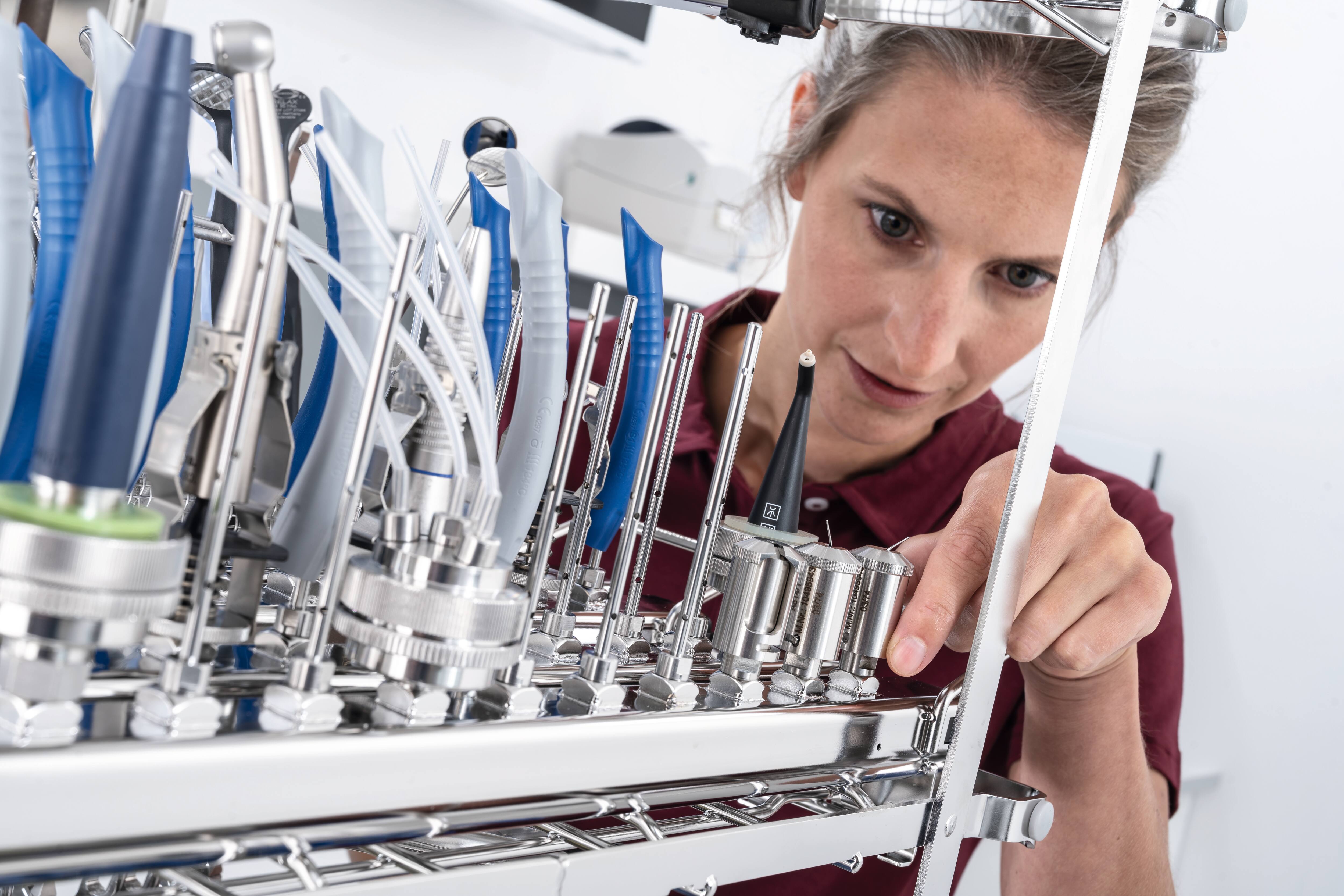  A woman's hands cover a hotel bed. The sheets are white.Restaurants: An employee at the Restaraunt sets the table.