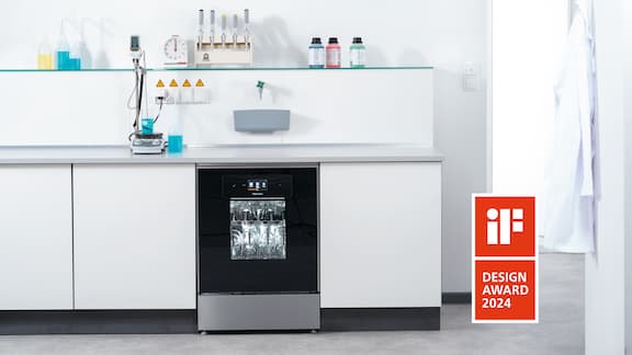 En ExpertLine-laboratorieopvaskemaskine med glasdør indbygget i et arbejdsbord. Logoet for iF Design Award 2024 kan også ses.