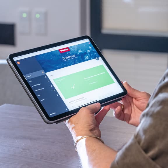Hand with tablet – represents Miele MOVE and digital process optimisation.