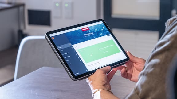 A tablet with Miele MOVE software showing machine data