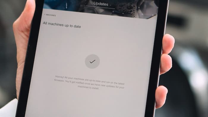 Ein Tablet Display mit der Information, dass alle Maschinen auf dem Laufenden sind.