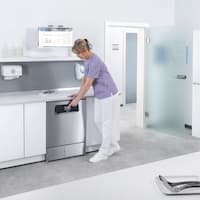A medical assistant selects programme on ExpertLine washer-disinfector in medical reprocessing room