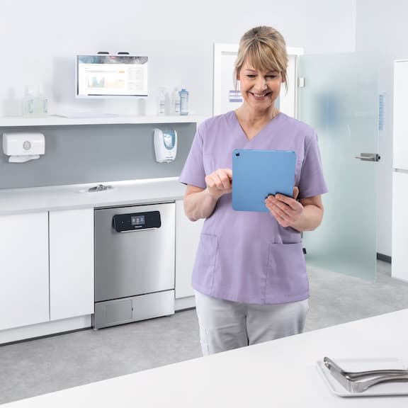 Medical assistant looks at tablet in reprocessing room