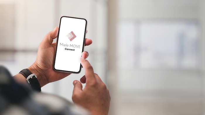 Smartphone displaying Miele MOVE Connect logo.