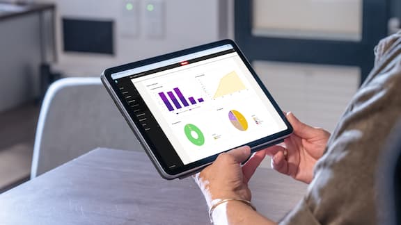 Person holding tablet showing product dashboard