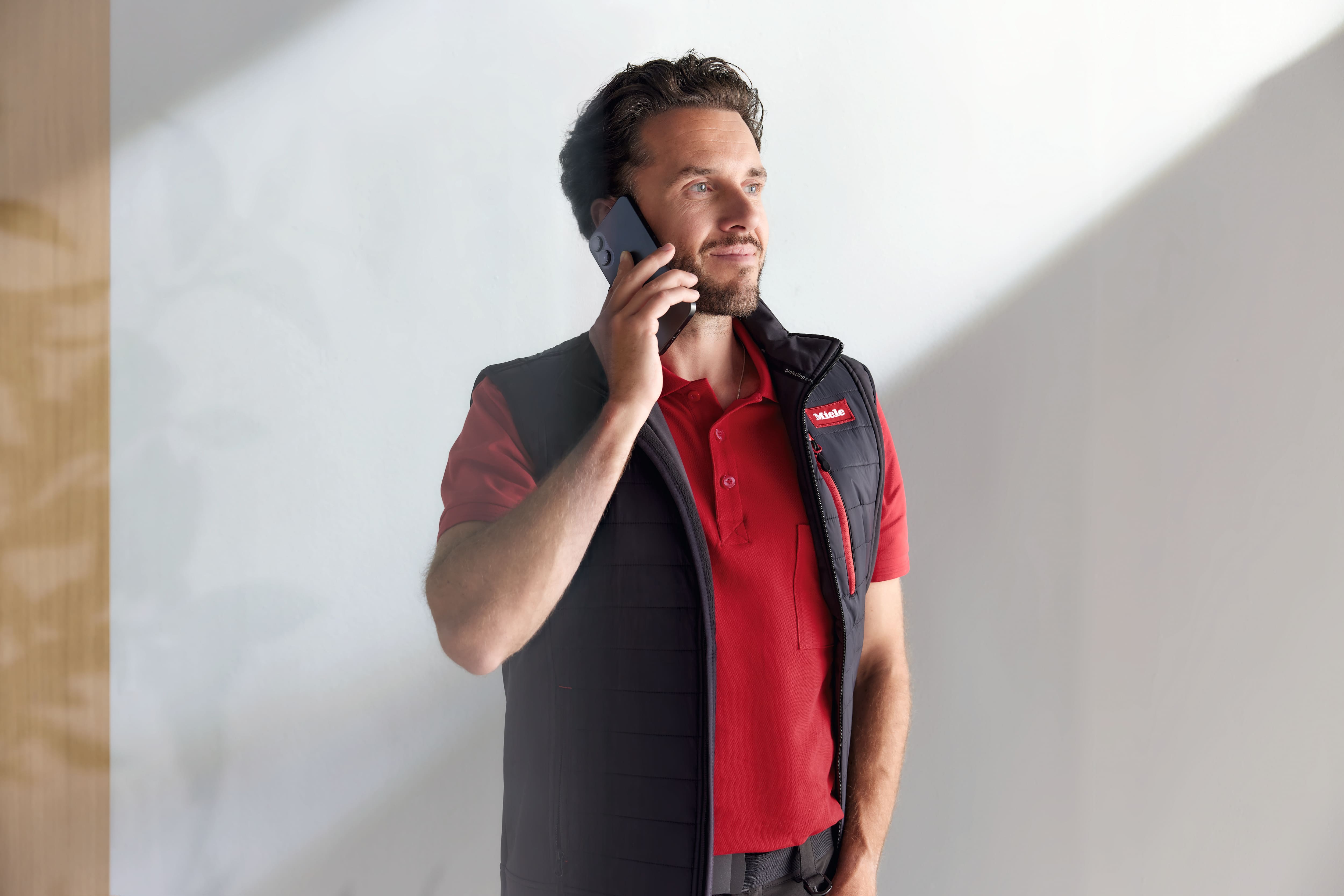 Technicien Miele passant un appel sur son smartphone Technicien Miele passant un appel sur son smartphone