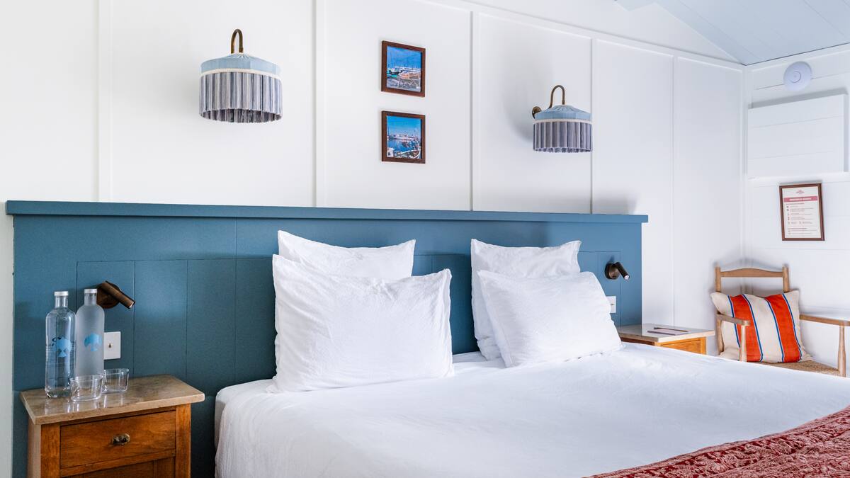 Habitación con una cama una silla y una mesilla de noche