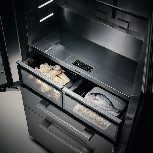 Detailed view of the first two drawers of the new MasterCool refrigerator opened. One contains some mushrooms and the other a fish and some clams