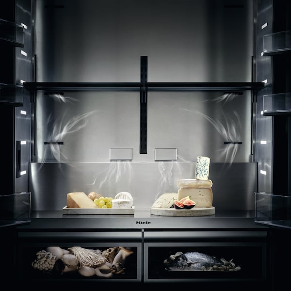 Detailed view of the new MasterCool refrigerator interior, front-facing, showcasing the placement of the filters. It shows a couple of cheese plates sitting inside, exemplifying how the odors get extracted through the filters.
