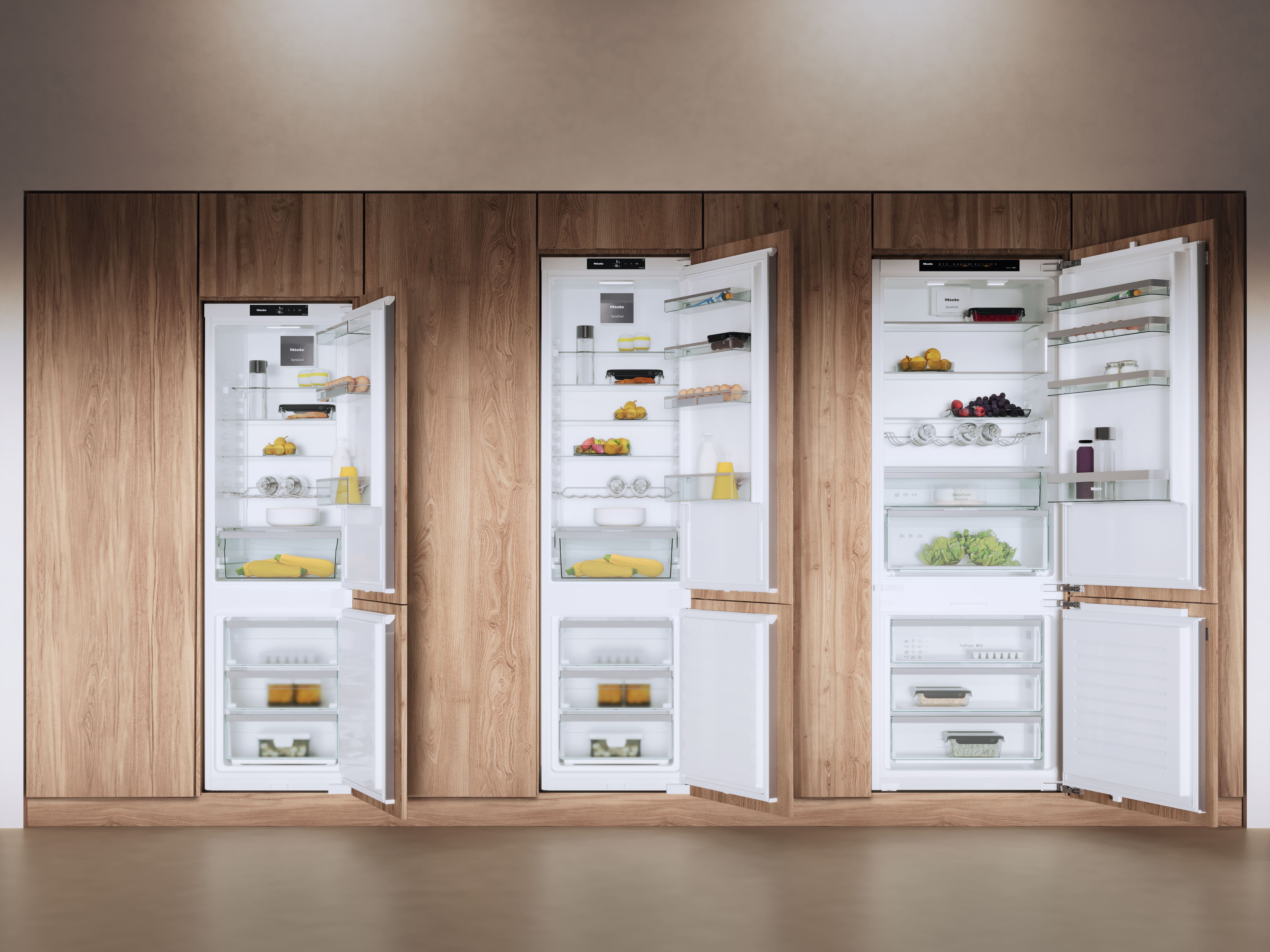 Three built-in fridges, with different sizes, open next to each other