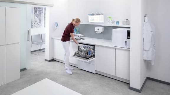 Une assistante dentaire décharge le laveur-désinfecteur CompactLine dans la salle de traitement.