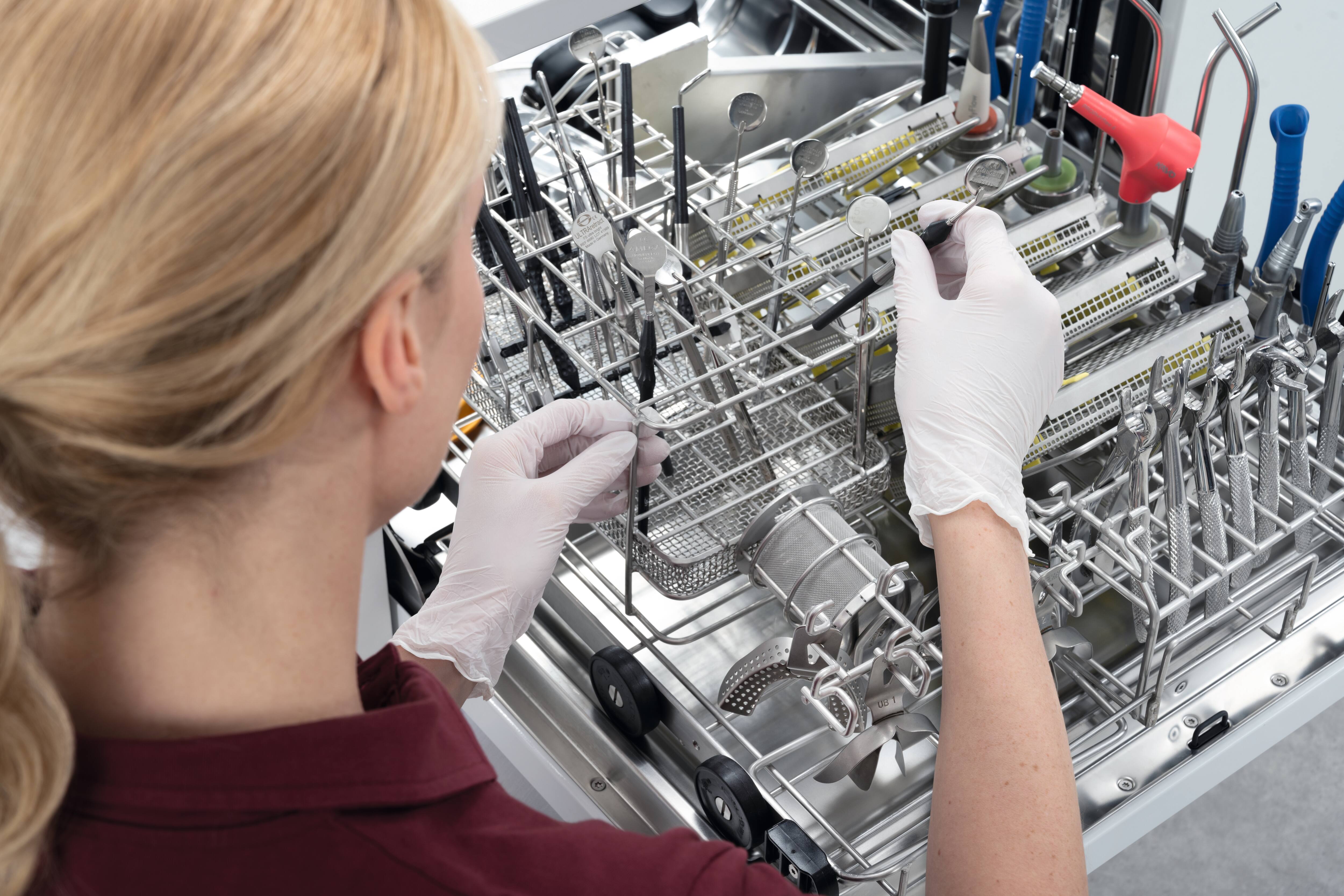 Doctor’s assistant stands at the tabletop washer-disinfector. ​