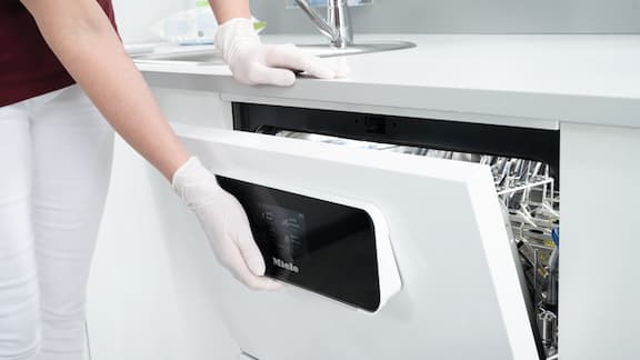 Une main ouvre la porte d’un laveur-désinfecteur CompactLine.