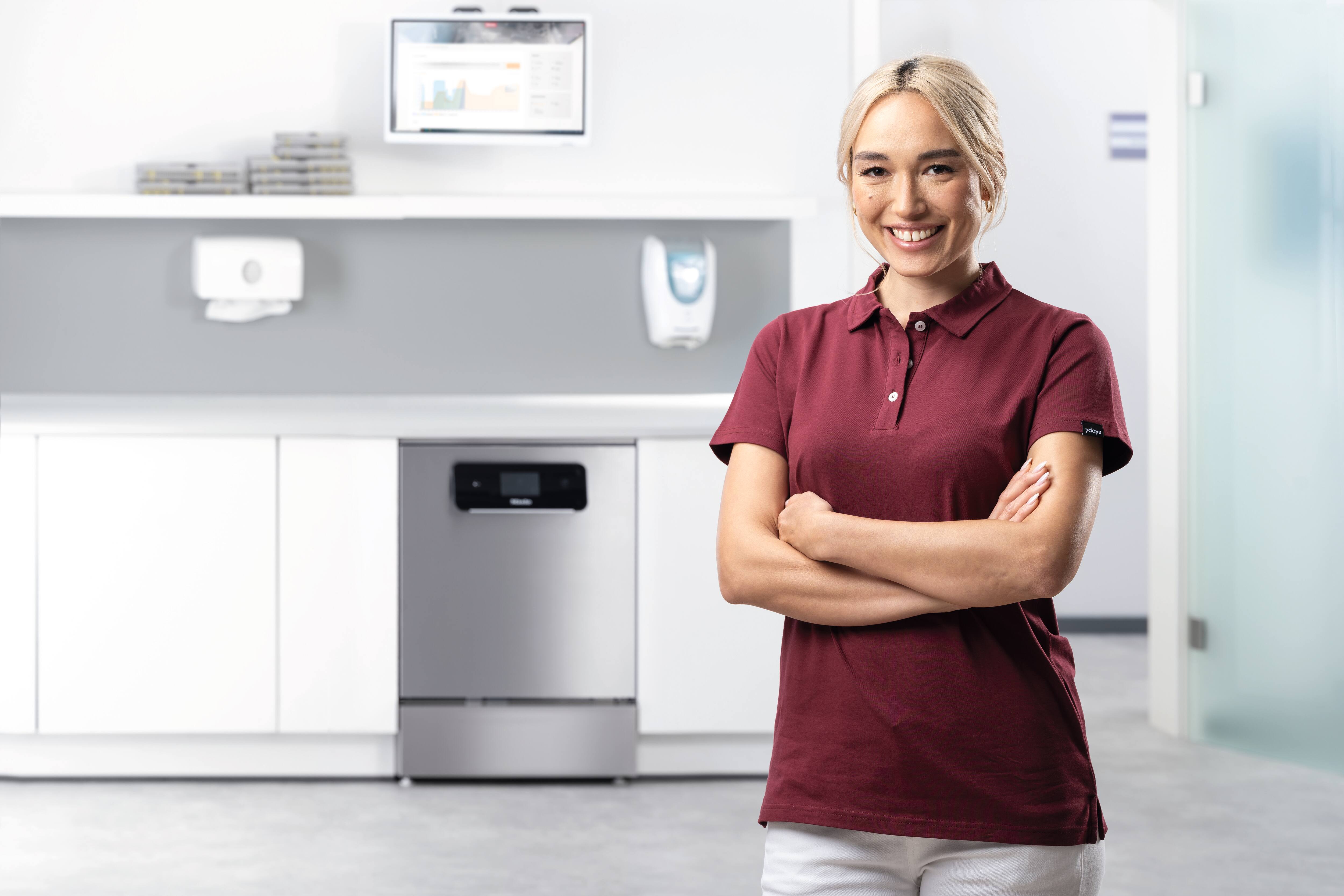 A dental assistant smiles in reprocessing room with ExpertLine machine