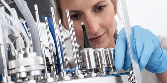 Een close-up van een tandarts die instrumenten controleert in een thermodesinfector