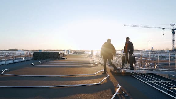 Two service technicians stepping onto the deck of a ship