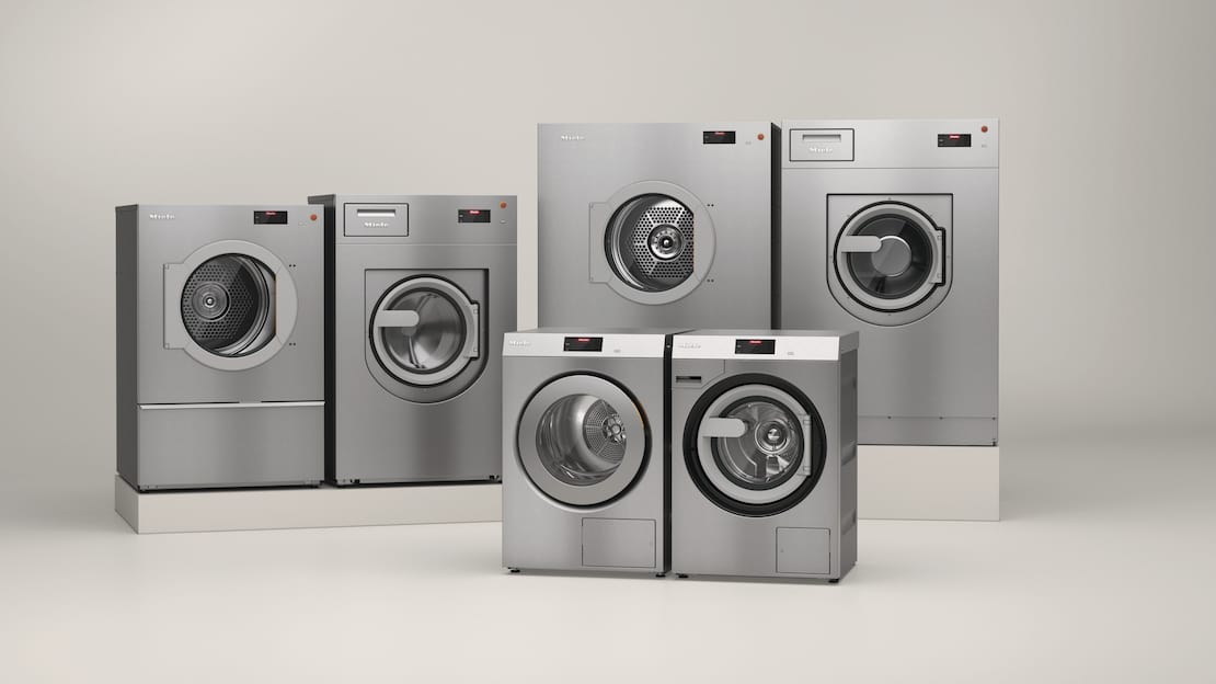 In one room, the commercial Benchmark Performance Plus washing machines and tumble dryers stand next to each other from left to right: PDR 914, PWM 912, PDR 928, PDR 927. The PDR 910 tumble dryer and the PWM 909 washing machine are in the foreground