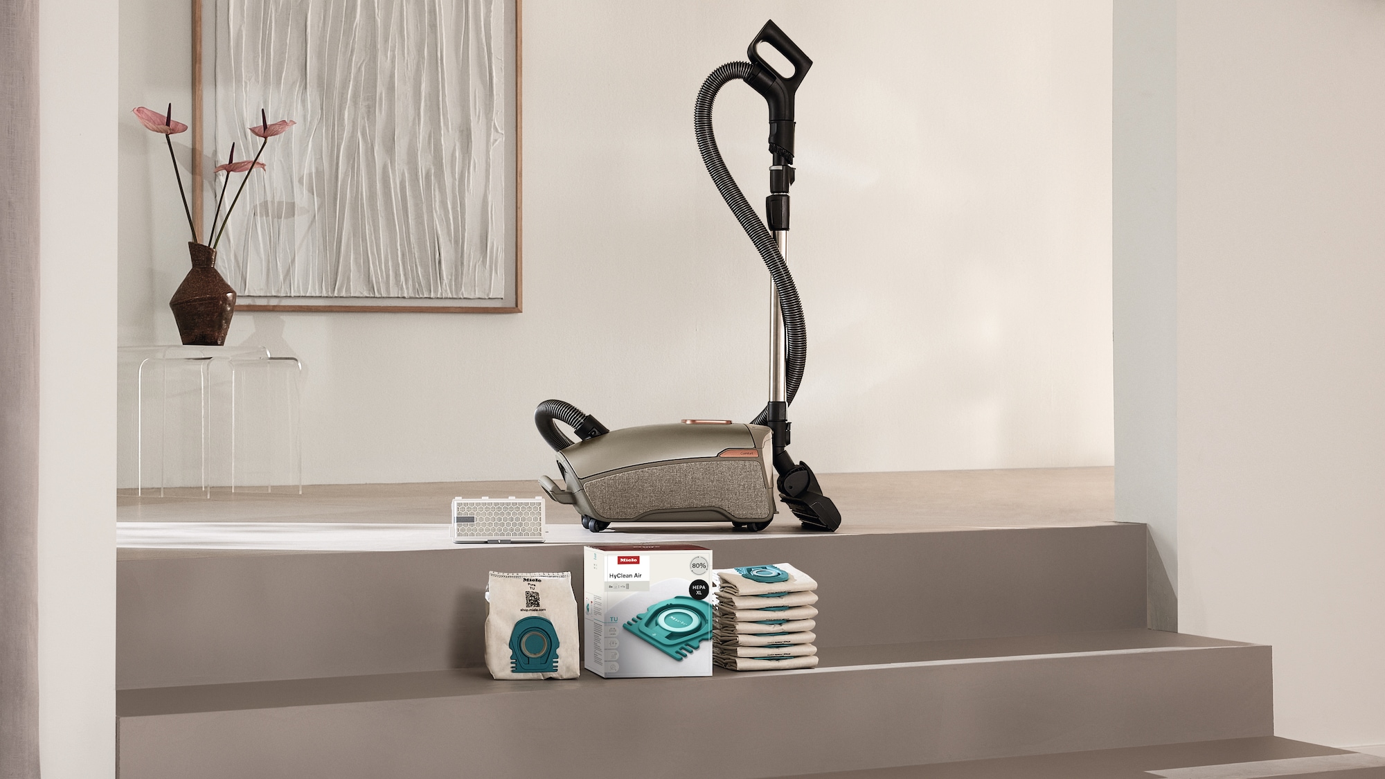 Image of vacuum cleaner bags and filters next to a canister vacuum