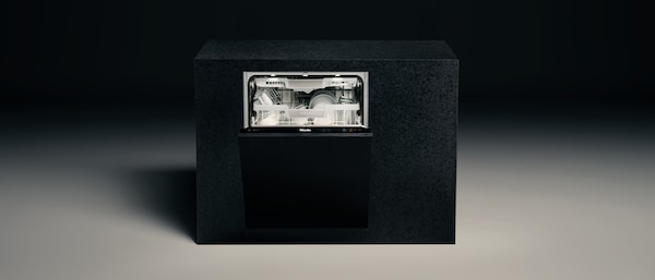 Miele Dishwasher with its door opened, standing alone in a dark background setting