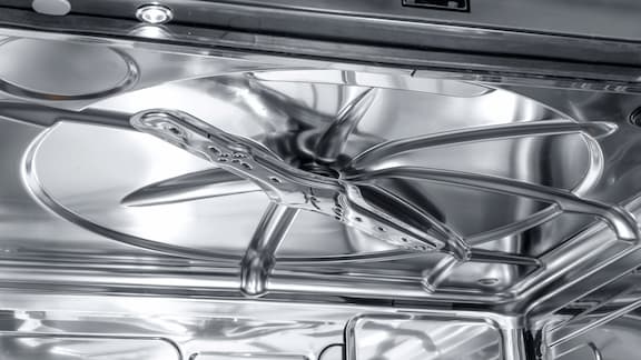 O braço de lavagem de uma máquina de lavar e desinfetar CompactLine dentro da cuba da máquina