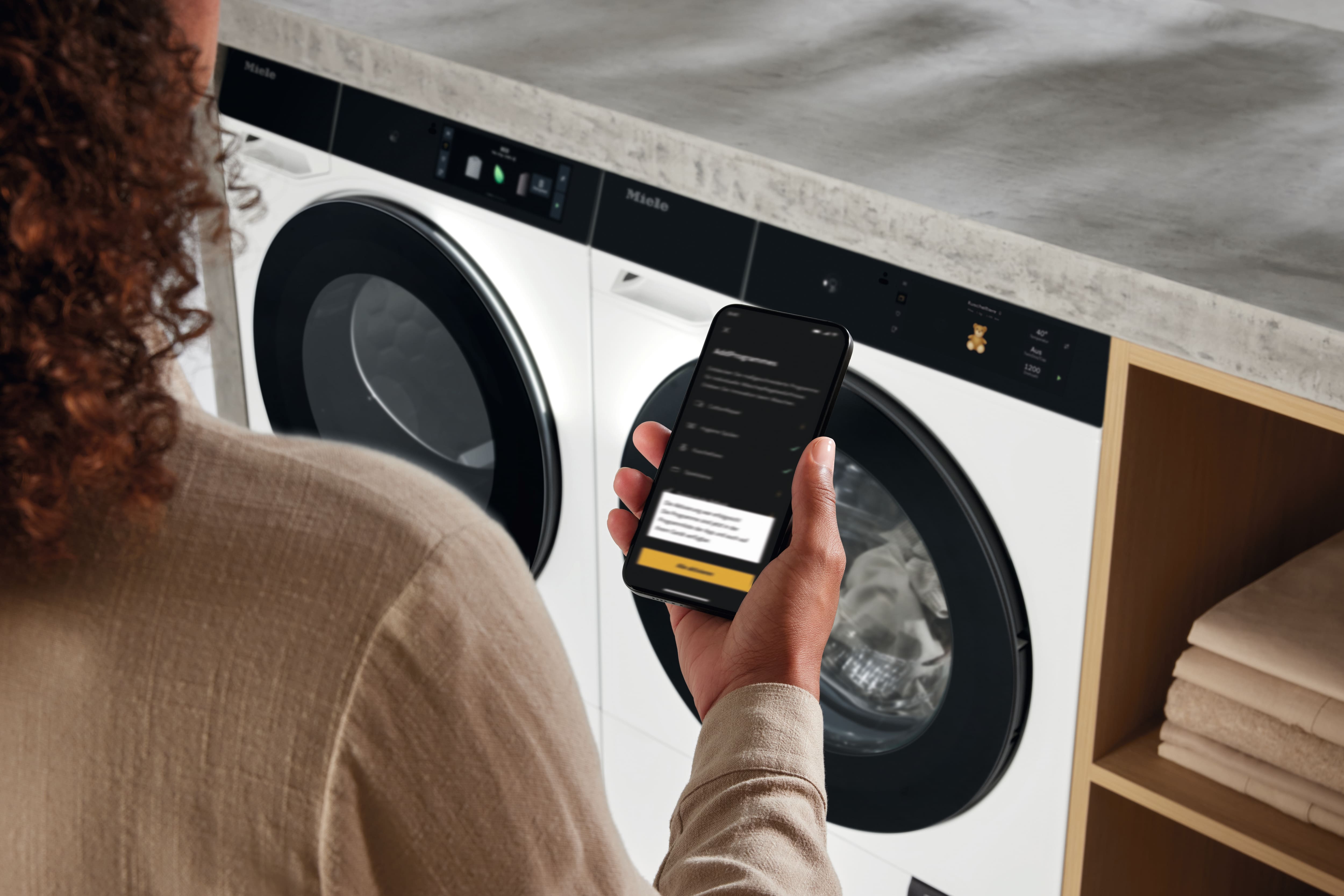 Žena si na mobile aktivuje záruku cez Miele app 