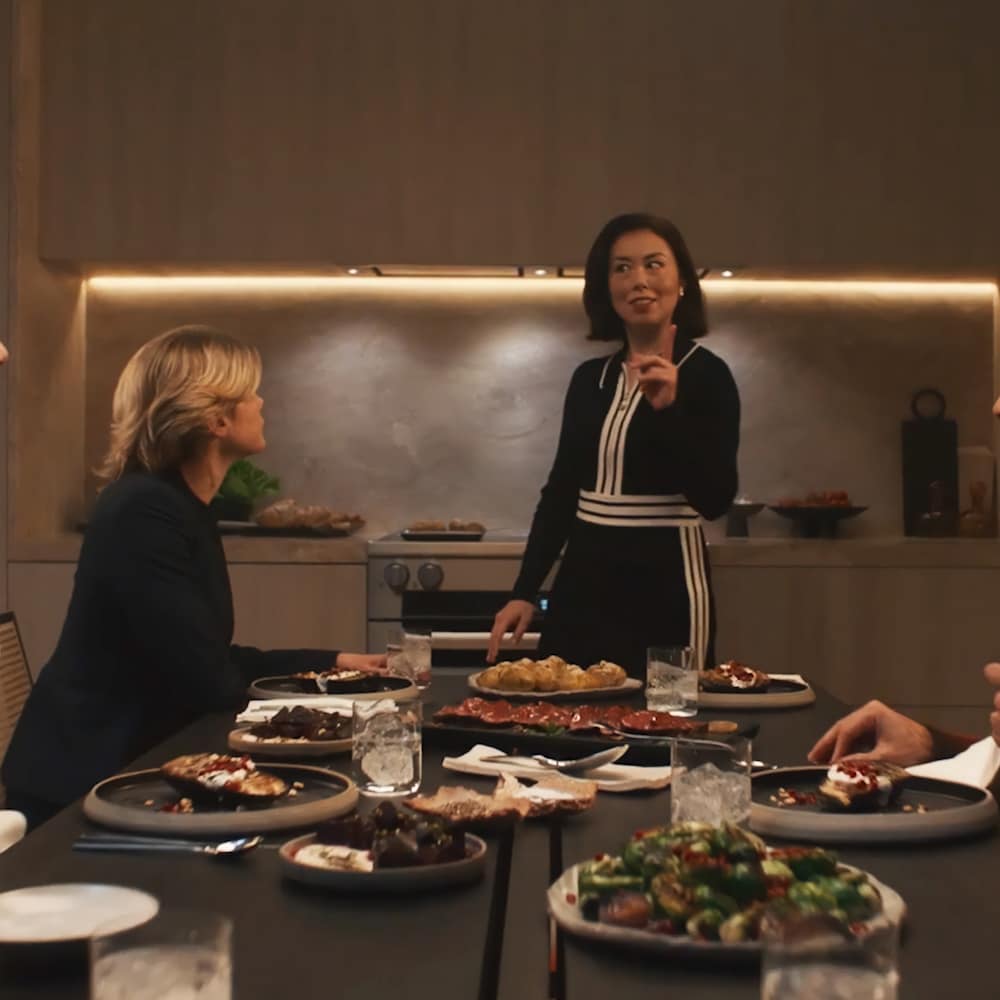 People talking around a table in a kitchen