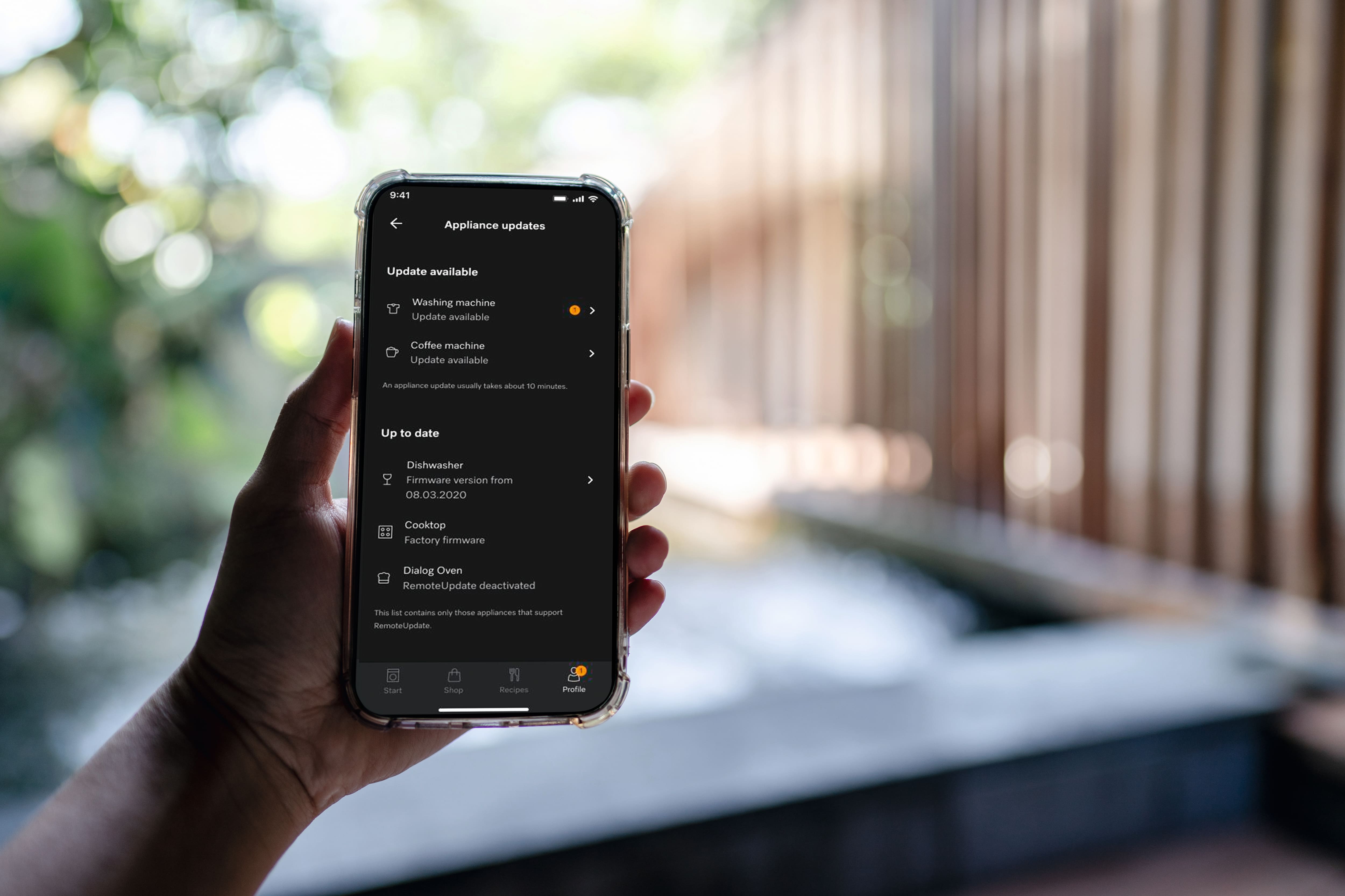 Person holding a phone with the Miele app open