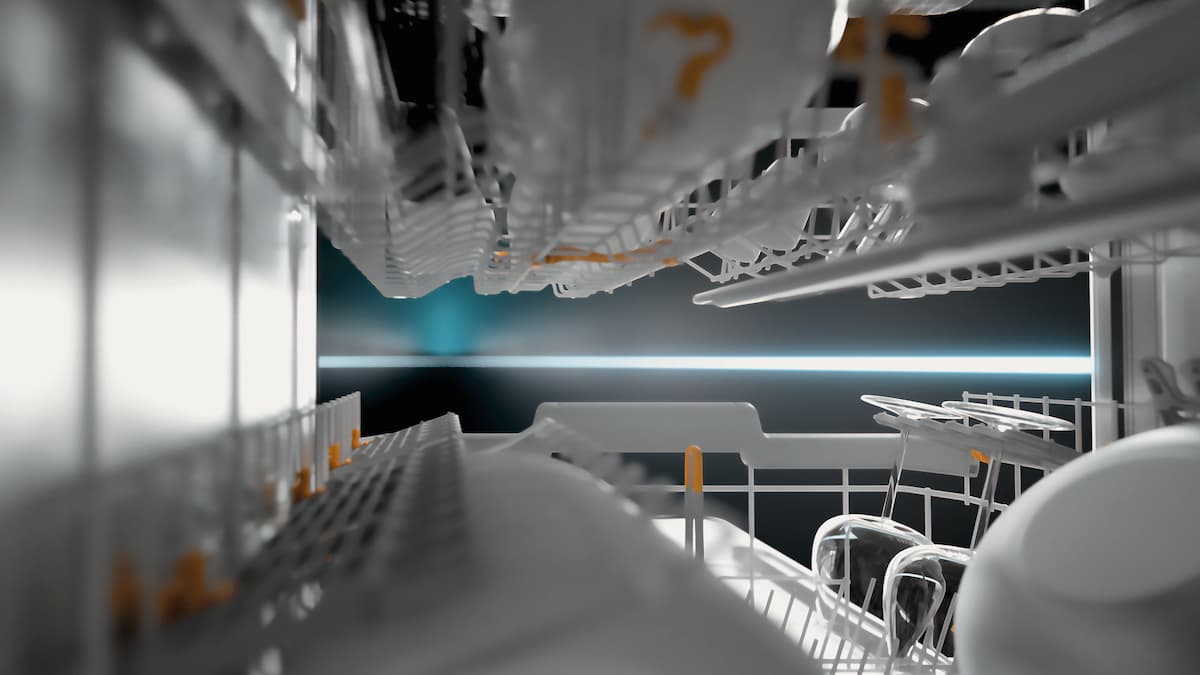 View inside a dishwasher with white crockery, a blue LED light in the background.