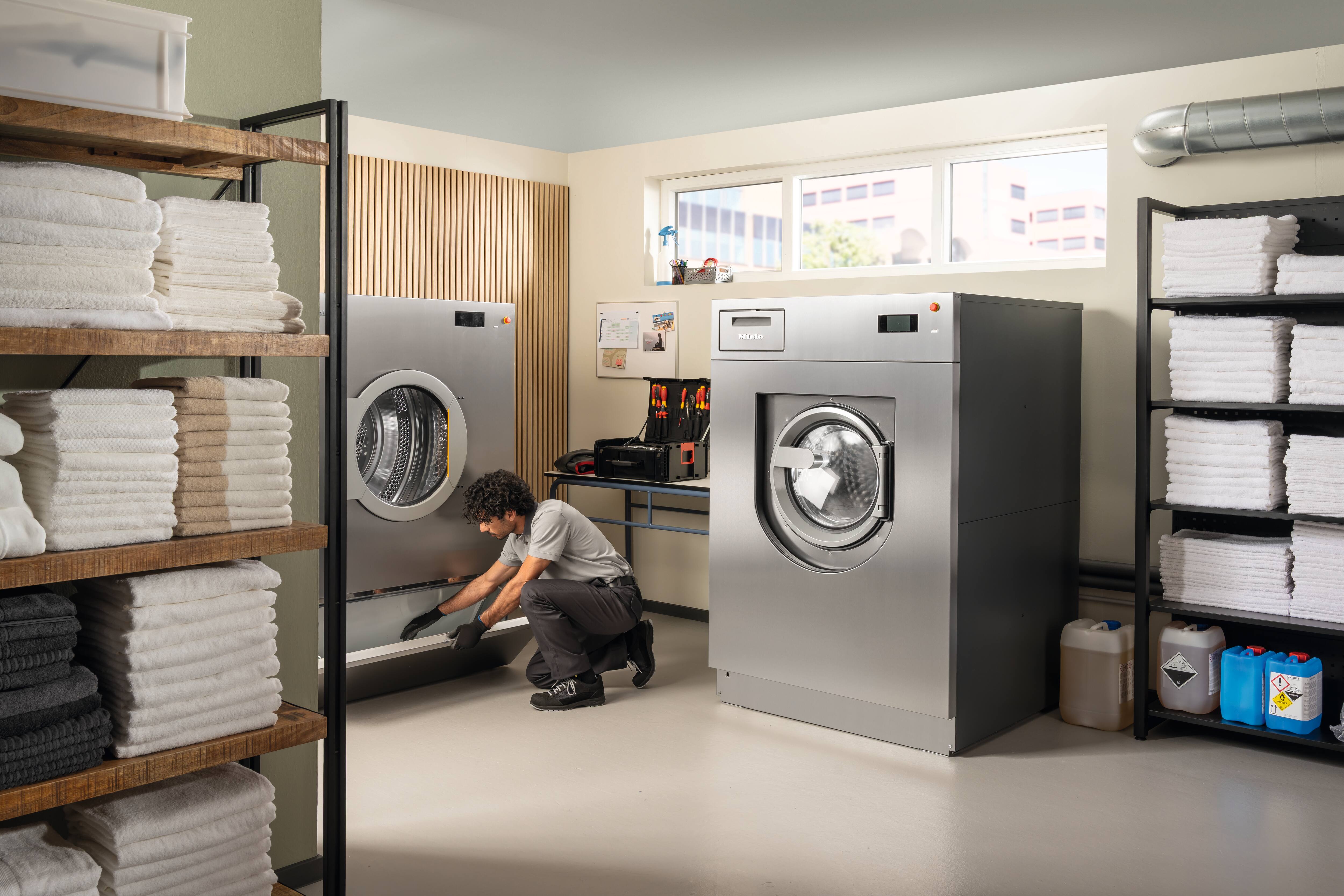 A Miele service technician checks the fluff filter box of the Miele Benchmark Performance Plus PDR 928 tumble dryer