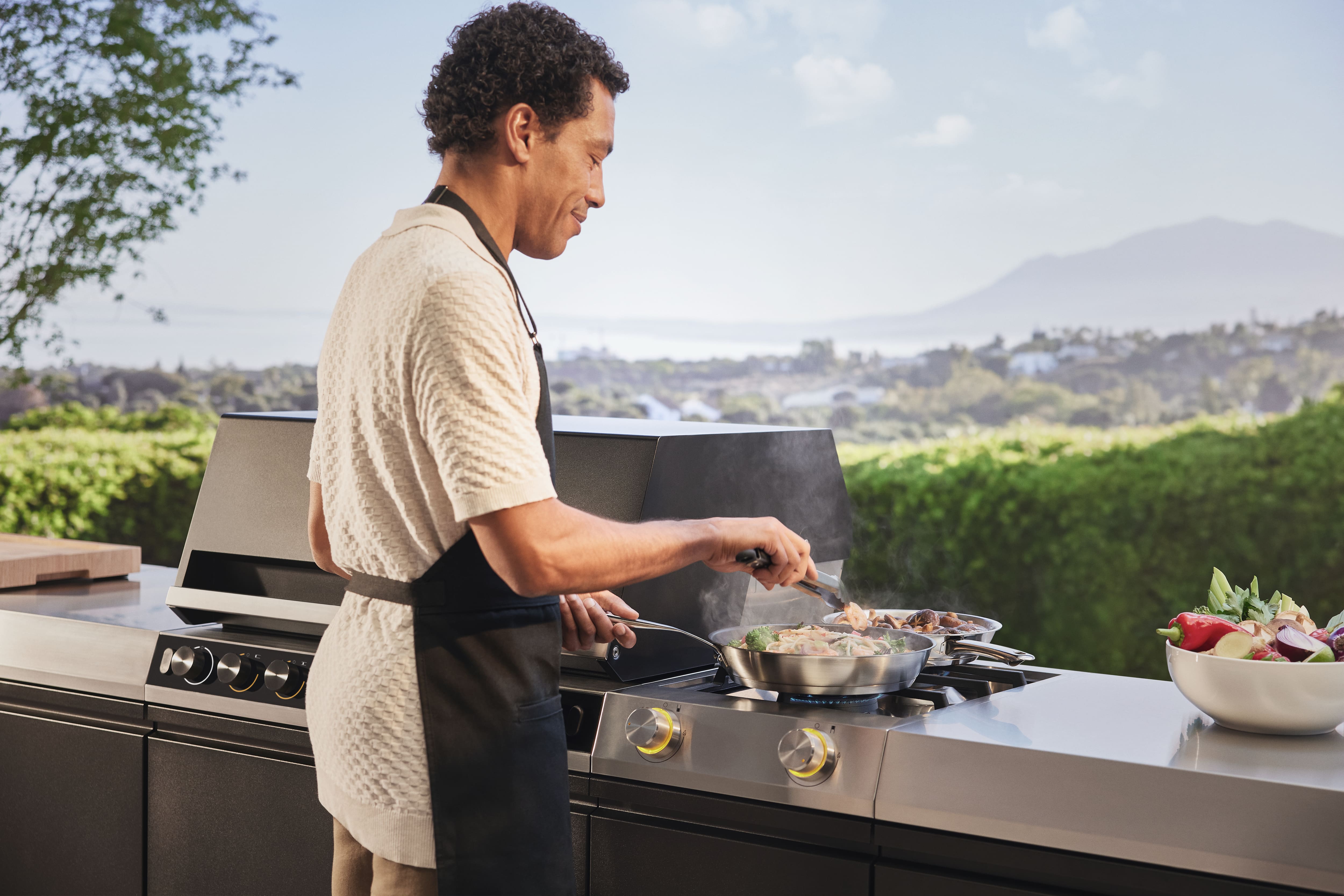 Mann benutzt die Außenküche Mann benutzt die Außenküche