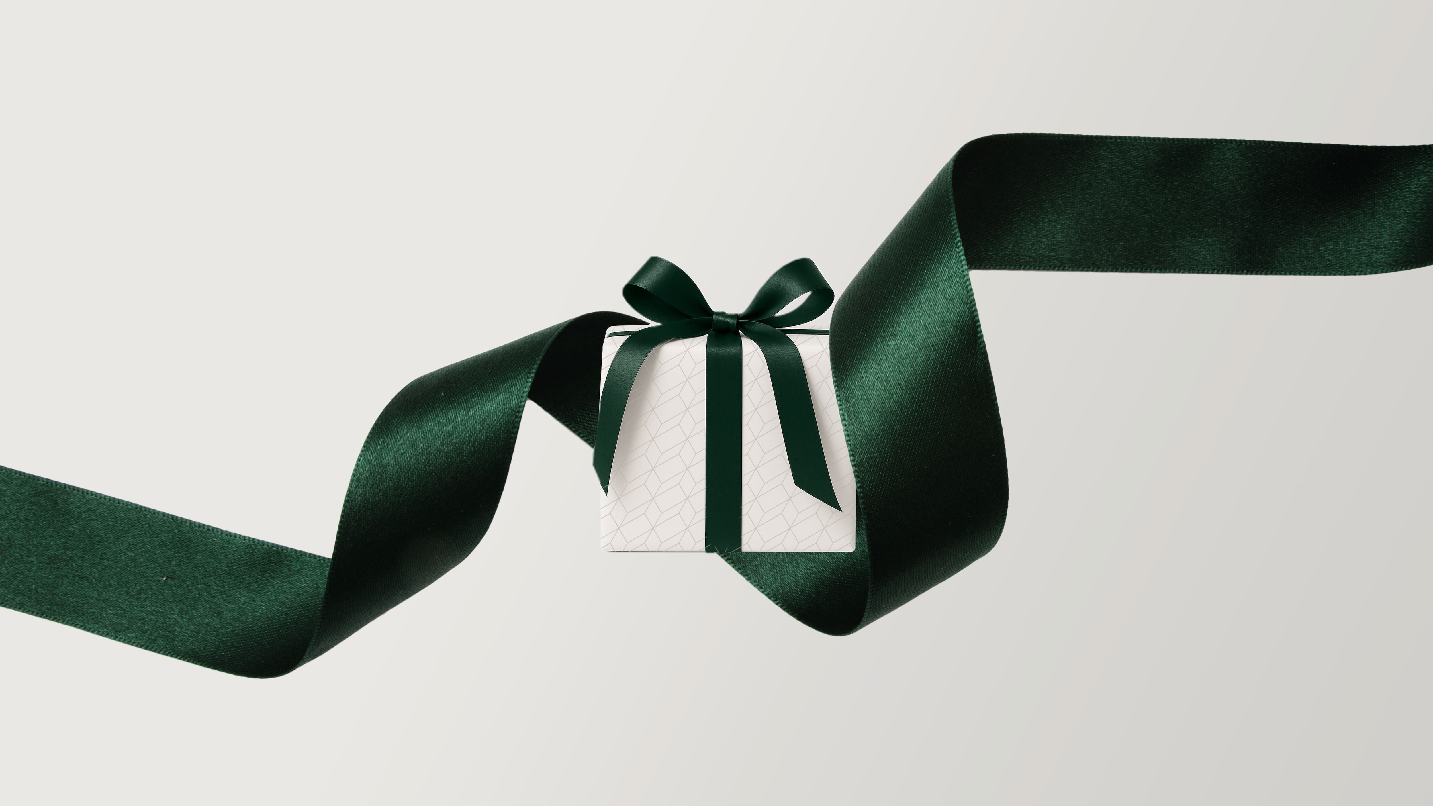 Świąteczna grafika Miele z prezentem owiniętym elegancką wstążką prezentową Świąteczna grafika Miele z prezentem owiniętym elegancką wstążką prezentową