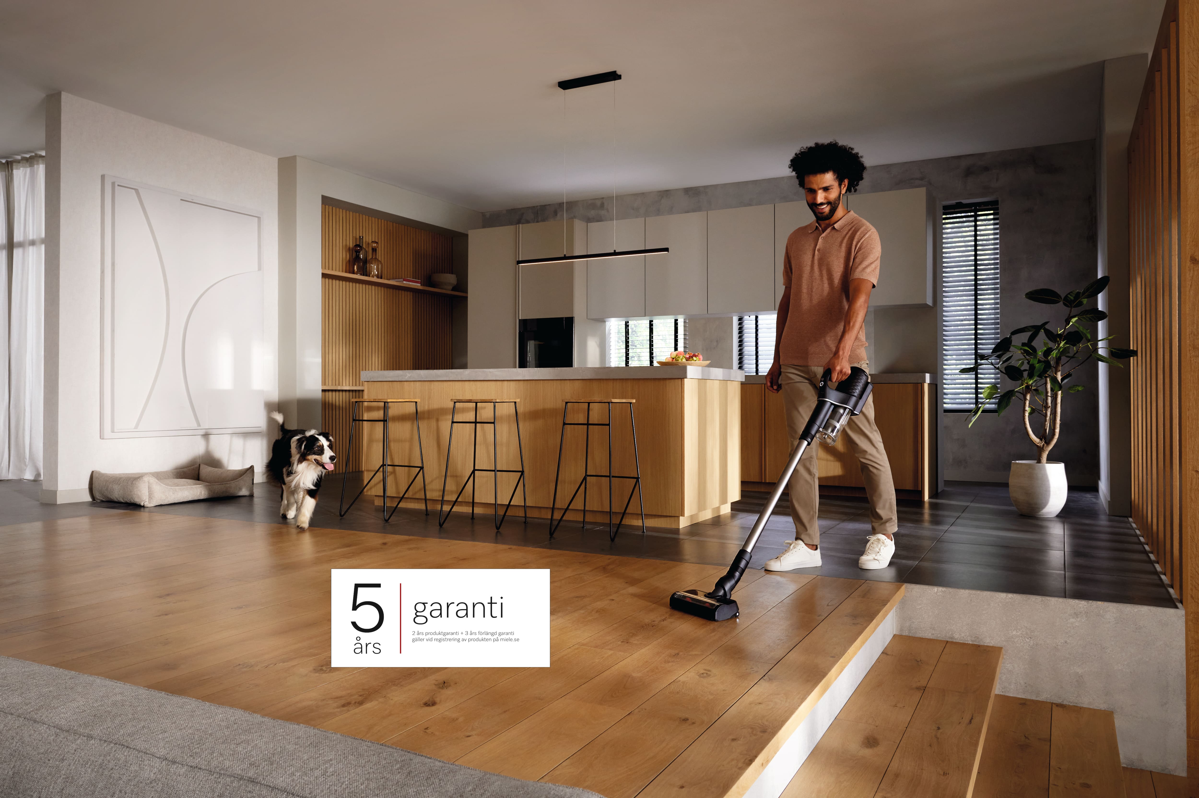 Man dammsugar med den sladdlösa dammsugaren Duoflex