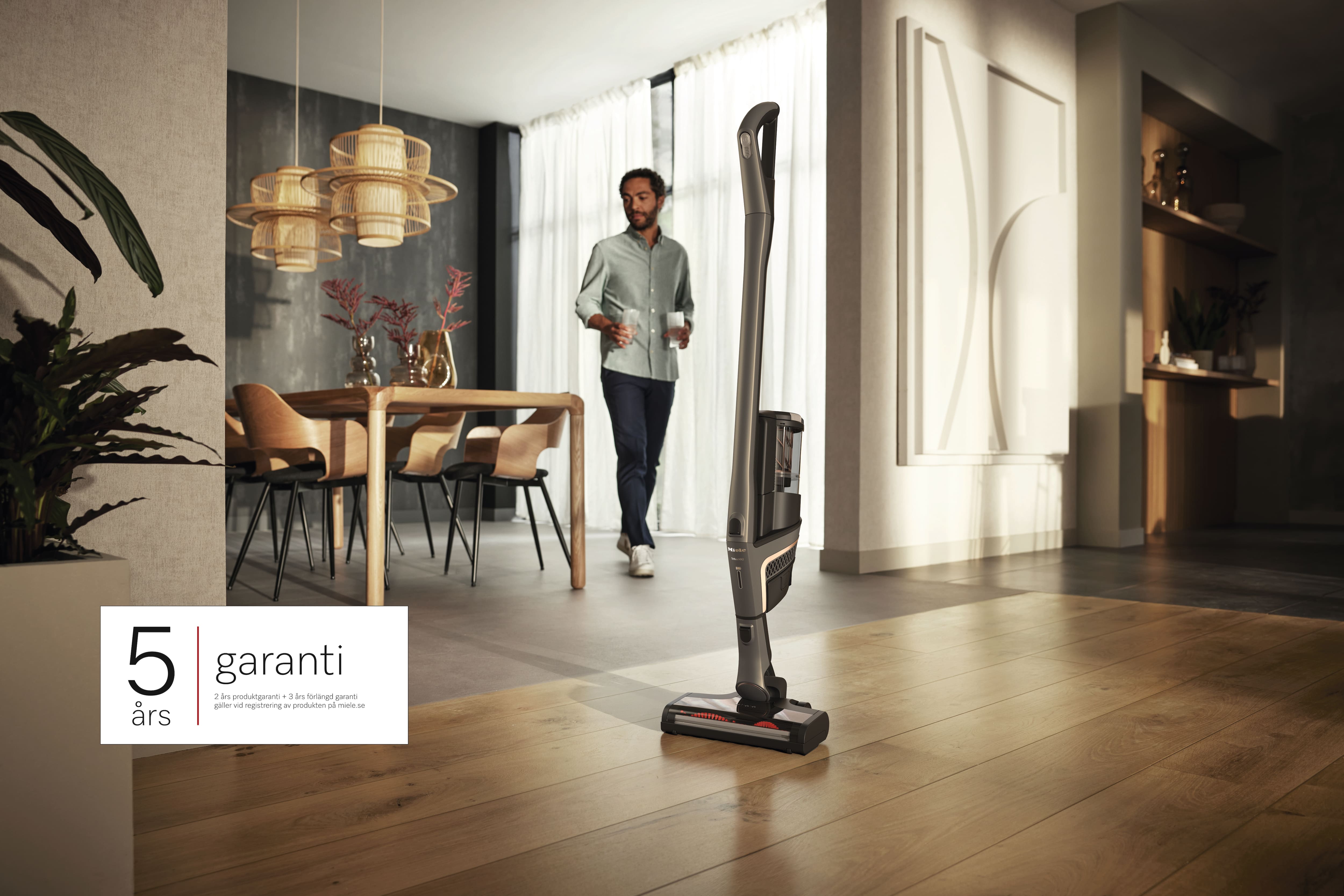 Triflex HX2 sladdlös dammsugare uppställd mot vit vägg och med logotyp 5 års garanti