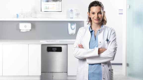L'assistente apre la macchina speciale per il lavaggio e la disinfezione nel locale di trattamento.