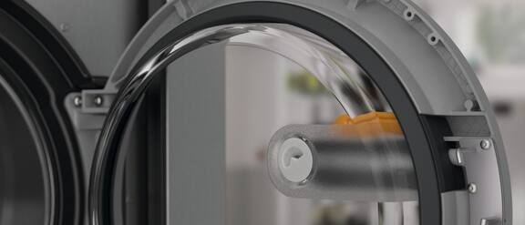 Detailaufnahme der Innenseite der Tür der Benchmark PowerWash PRO PWM 920 PWP Waschmaschine. Es ist die Öffnung innerhalb des Türgriffs zu sehen mit der Sprühdüse.