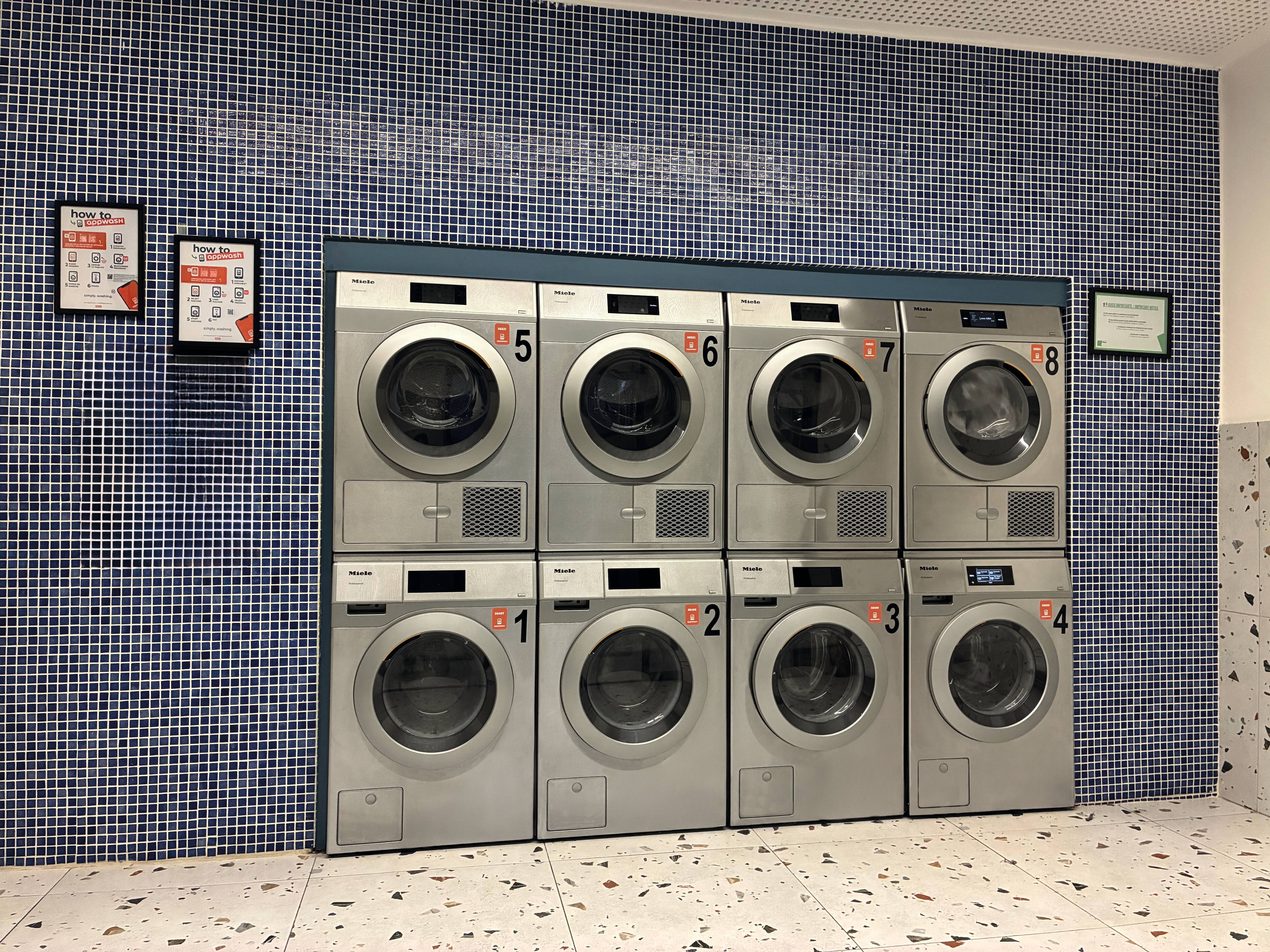 Una lavandería con 8 máquinas y carteles de appWash